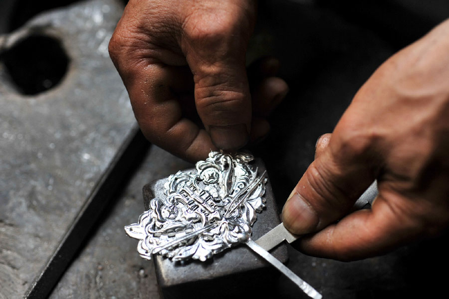 Using his tools, Ma Maoting processes silver jewelry. (Photo/Xinhua)