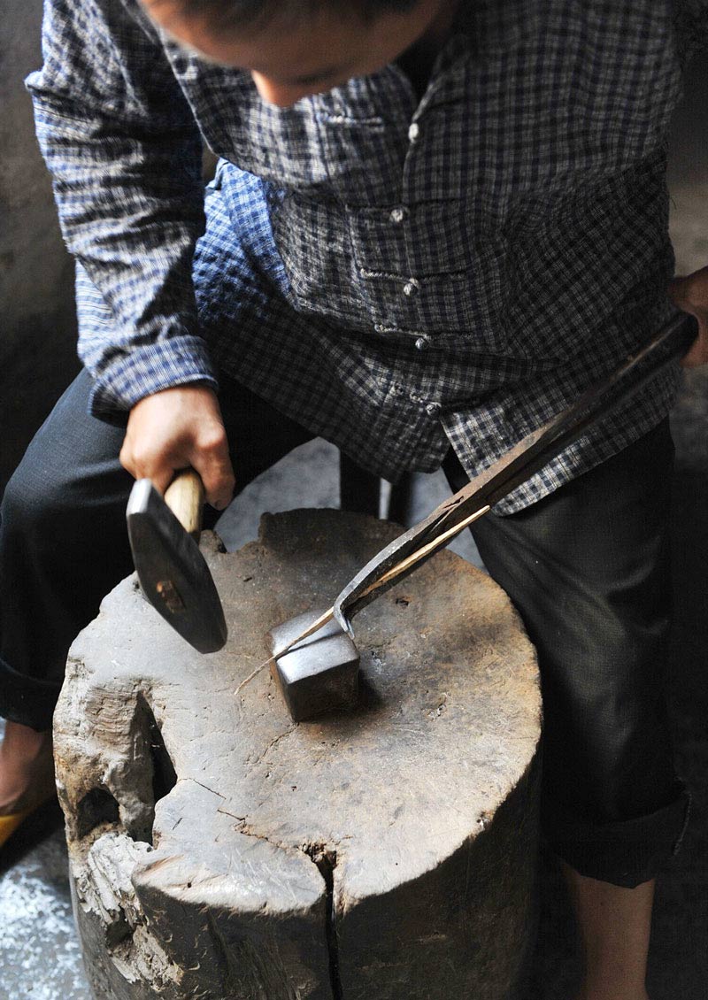 Using his tools, Ma Maoting processes silver jewelry. (Photo/Xinhua)