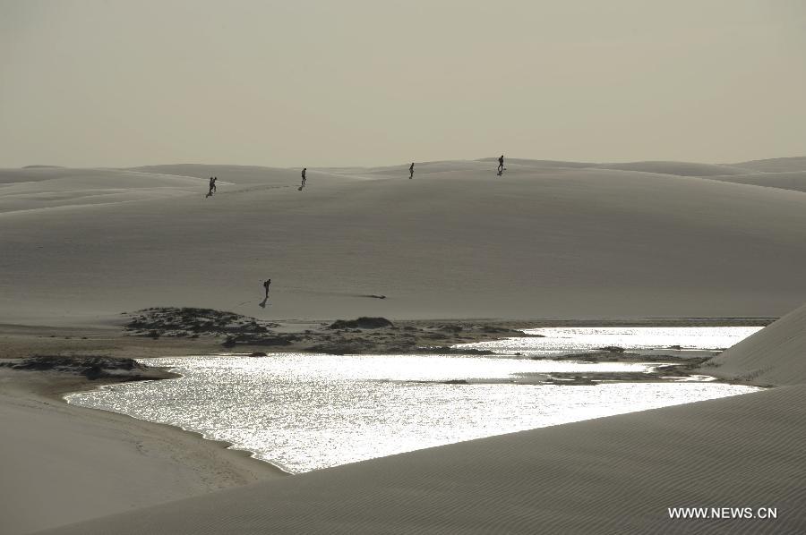 People visit Lencois Maranhenses National Park located in northeast Brazil's Maranhao state, July 28, 2013. At the end of rain season every year, crystal clear lagoons form in the desert here.(Xinhua/Weng Xinyang)