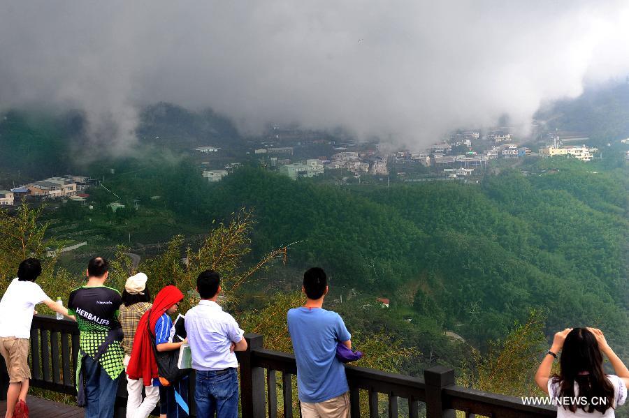 Tourists view scenery at Xiding in the Alishan scenic area in Chiayi, southeast China's Taiwan, July 29, 2013. Xiding is one of the best places to view mist and sunrise in the scenic area. (Xinhua/Tao Ming)