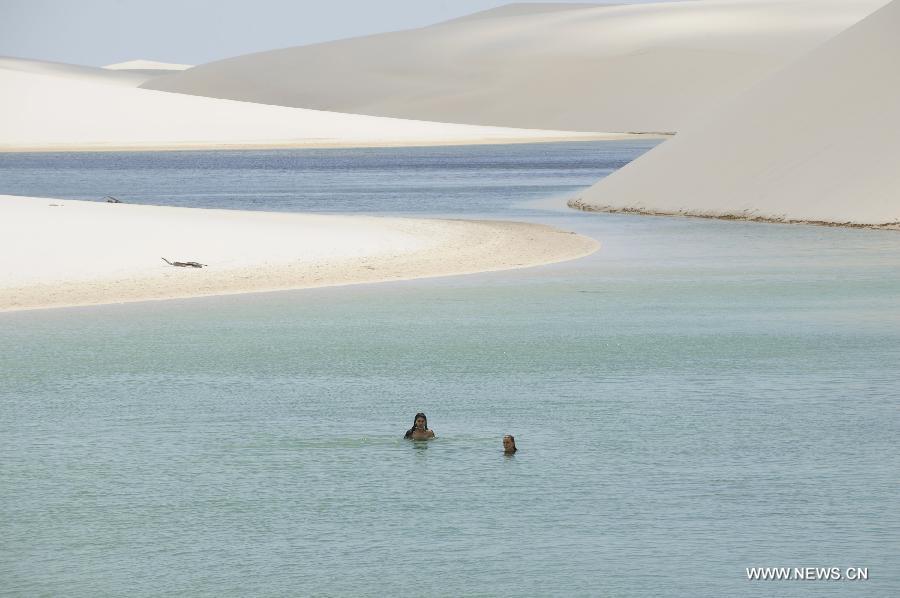 People visit Lencois Maranhenses National Park located in northeast Brazil's Maranhao state, July 28, 2013. At the end of rain season every year, crystal clear lagoons form in the desert here.(Xinhua/Weng Xinyang)
