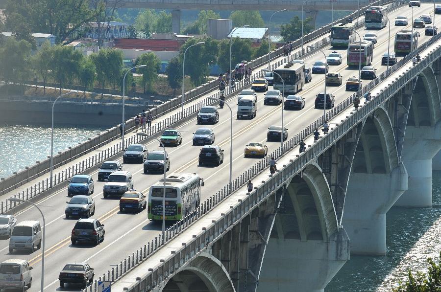 Vehicles travel on the Juzizhou Bridge in Changsha, capital of central China's Hunan Province, July 30, 2013. High temperatures sustained in the past month in Changsha and will continue in the coming 4 days. (Xinhua/Long Hongtao)