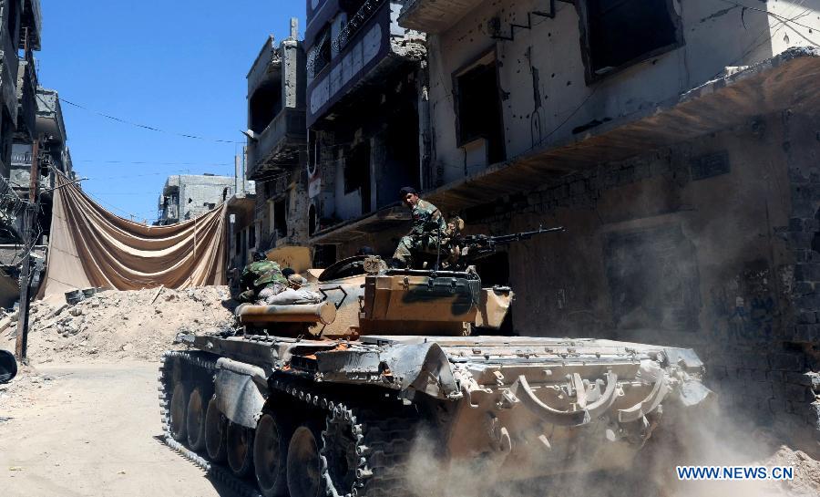 Soldiers of the Syrian army in a tank are seen in the street of al-Khalidieh district in central Homs province, Syria, July 30, 2013. The Syrian army announced Monday that its troops successfully regained full control over the strategic al-Khalidieh district in central Homs province after a series of precise operations there, according to the state-TV. (Xinhua/Zhang Naijie)