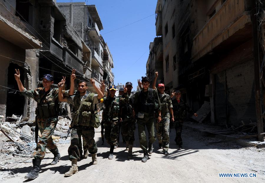 Soldiers of the Syrian army cheer their victories in the street of al-Khalidieh district in central Homs province, Syria, July 30, 2013. The Syrian army announced Monday that its troops successfully regained full control over the strategic al-Khalidieh district in central Homs province after a series of precise operations there, according to the state-TV. (Xinhua/Zhang Naijie)