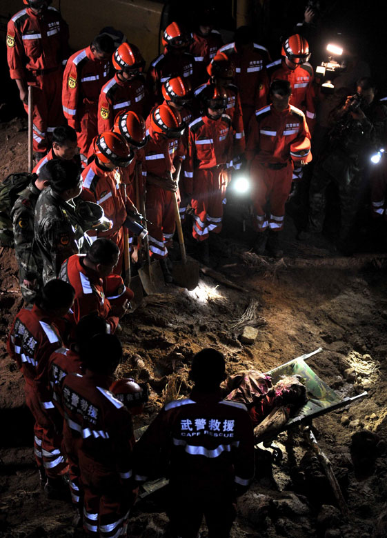 The rescue workers mourn for the 11th victims on July 23, 2013. At 4 a.m., 12 people from five families were buried in a landslide in Minxian county, northwest China’s Gansu province. 11 of them had been founded dead and the rescue workers were searching for the 12th villager. (Xinhua/Luo xiaoguang) 