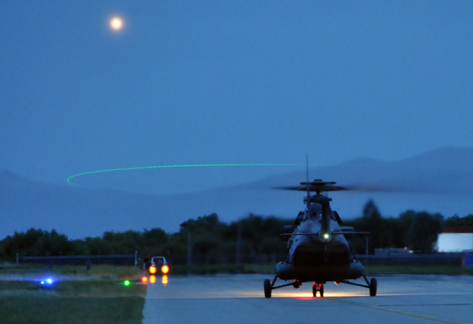 A helicopter of Chinese air force takes off from a Tibetan airport for the flight exercise at the night, July 21, 2013. (Xinhua/Li Liangfeng) 