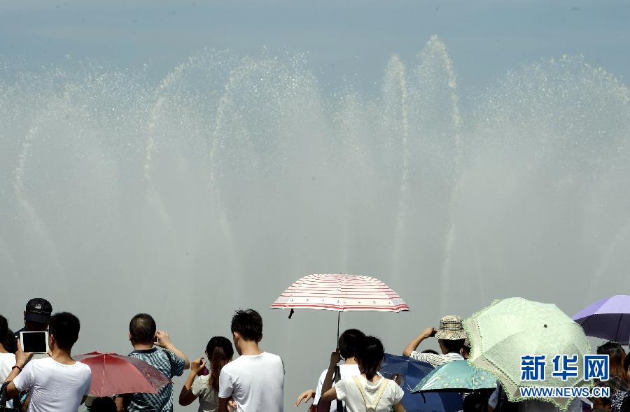 People enjoy music fountain in Hubin Park in Hangzhou on July 28, 2013. Temperatures in many regions in Zhejiang had exceeded 40 degrees Celsius for many days since July, with average precipitation reduced 70 percent. (Xinhua/Shi Jianxue)