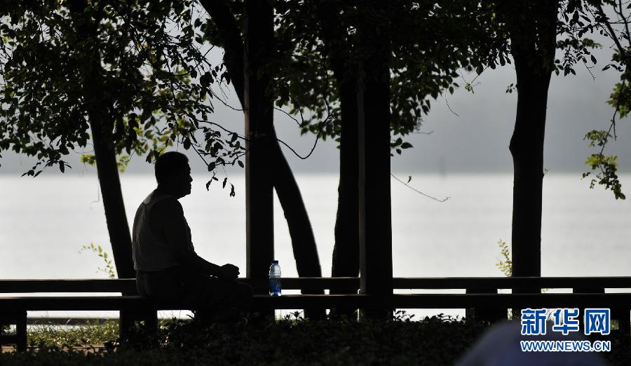 A citizen cools off under shades in Xuanwu park in Nanjing, east China on July 29, 2013. The highest temperature in Nanjing surpassed 35 degrees Celsius for seven consecutive days. (Xinhua/Li Xiang)