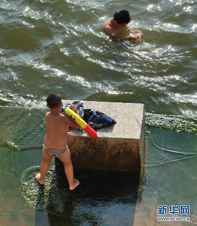 Citizen of Changsha play by the Xiangjiang River, July 30, 21013. The heat wave has hit Changsha, the capital city of Hunan province. It is predicted that the high temperature will persisit in the four days to come. The heat has already severely influenced citizen’s daily life. (Xinhua/Long Hongtao)