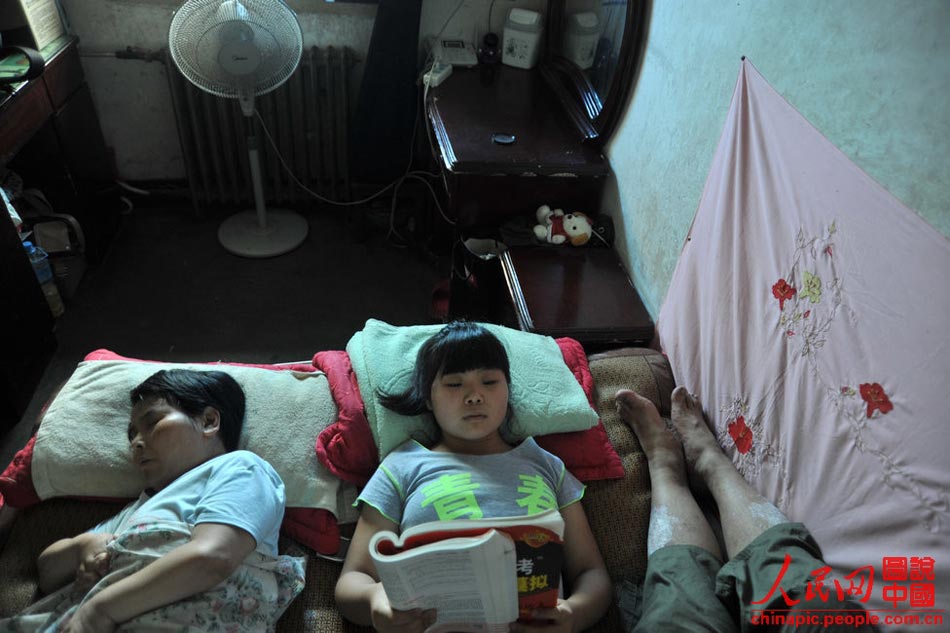 Five family members live in the small two-bedroom apartment. Gao has to share the bed with her parents. A volunteer donated a bed to Gao, but the parents can't find the space to place it. (Xinhua/Hu Linyun)