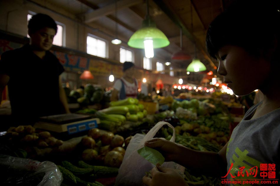 After school, Gao goes to the market for groceries shopping on July 12, 2013. The young girl is the "eyes" for her whole family. (Xinhua/Hu Linyun) 