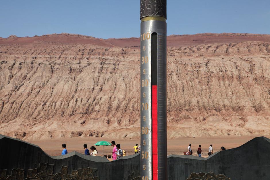 Tourists visit Huoyan mountain of Turpan city to the southeast of Urumqi, capital city of Xinjiang Uygur Autonomous Region of China on July 30, 2013. The giant thermometer in the Huoyan mountain of Turpan showed the temperature surpassed 78 degrees Celsius. (Photo/gmw.cn)