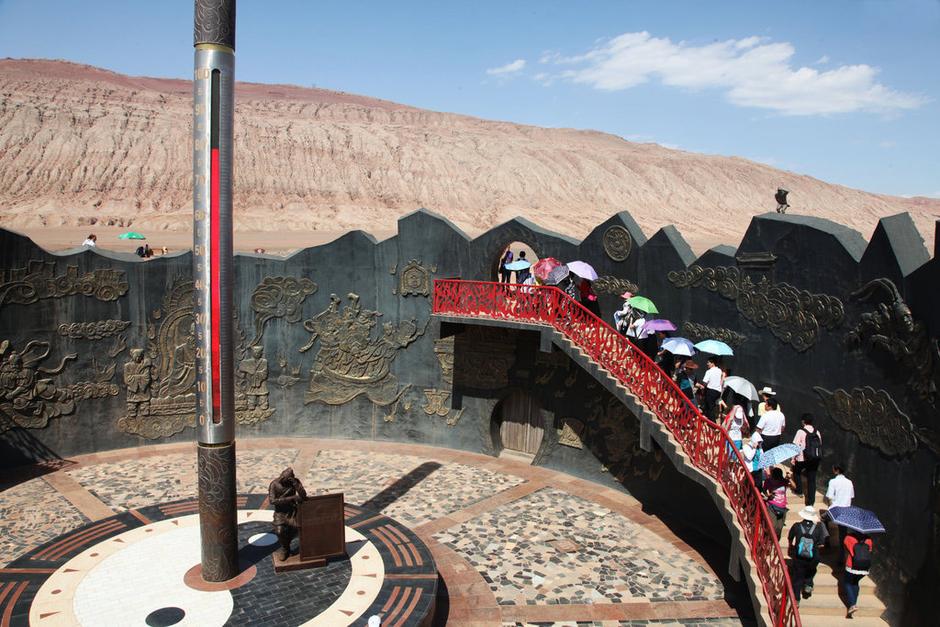 Tourists visit Huoyan mountain of Turpan city to the southeast of Urumqi, capital city of Xinjiang Uygur Autonomous Region of China on July 30, 2013. The giant thermometer in the Huoyan mountain of Turpan showed the temperature surpassed 78 degrees Celsius. (Photo/gmw.cn)