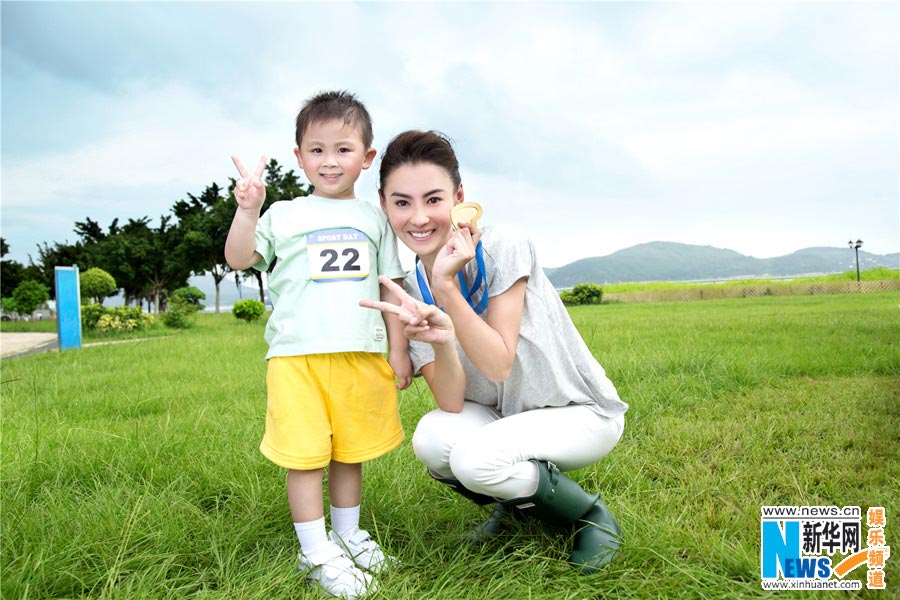 Chinese actress Cecilia Cheung poses for photos of an advertisement with a cute boy. (Photo/Xinhua)