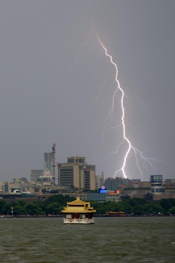 A lightning appears in the sky above the West Lake in Hangzhou, capital of east China's Zhejiang Province, July 30, 2013. Hangzhou City underwent a rainmaking on Tuesday afternoon. (Xinhua/Li Zhong) 