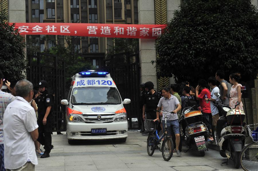 An ambulance drives out of the residential area where a gun fight took place between policemen and drug dealers in the Chenghua District of Chengdu, capital of southwest China's Sichuan Province, July 31, 2013. A gun fight took place as drug dealers resisted arrest from the police. One suspect jumped from a building and was killed while another two were arrested. (Xinhua/Xue Yubin)