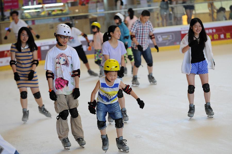 People enjoy ice skating to relieve the summer heat within a shopping mall in Hangzhou, capital of east China's Zhejiang Province, July 31, 2013. Hangzhou has experienced six days of temperature over 40 degrees Celsius since July 24. Indoor activities like ice skating and swimming has been popular among local citizens to relieve the intense heat. (Xinhua/Ju Huanzong)