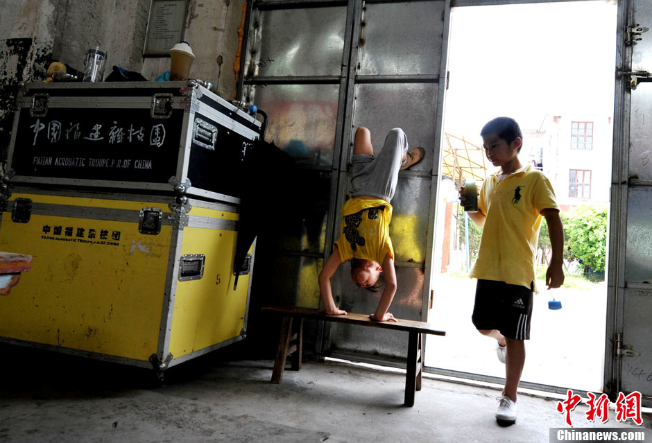 When others go to take a break, Xiuhua continues practicing handstands. (Chinanews/Wang Dongming)  