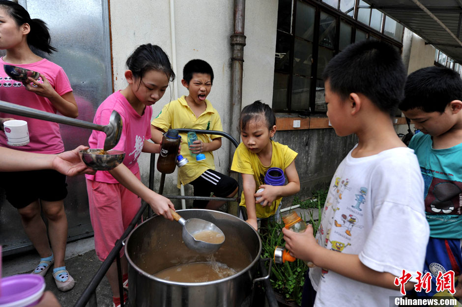 At lunch time, Xiuhua lets others take the gruel at first. As the youngest member in the troupe, Xiuhua usually shows respect to others. (Chinanews/Wang Dongming)