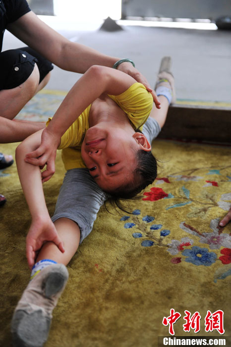 When practicing difficult moves, Xiuhua tolerates the pain with silence, and tears on her face. (Chinanews/Wang Dongming)