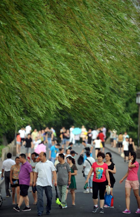 Visitors enjoy themselves on the Baidi Causeway at the West Lake after a thunder shower in Hangzhou, capital of east China's Zhejiang Province, July 31, 2013. A thunder shower on Wednesday brought cool to Hangzhou, a city that has experienced six days of temperature over 40 degrees Celsius since July 24. (Xinhua/Wang Dingchang)