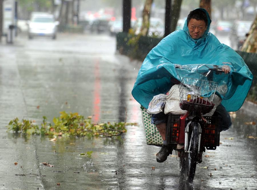 A man rides in rain in Hangzhou, capital of east China's Zhejiang Province, July 31, 2013. A thunder shower on Wednesday brought cool to Hangzhou, a city that has experienced six days of temperature over 40 degrees Celsius since July 24. (Xinhua/Wang Dingchang)