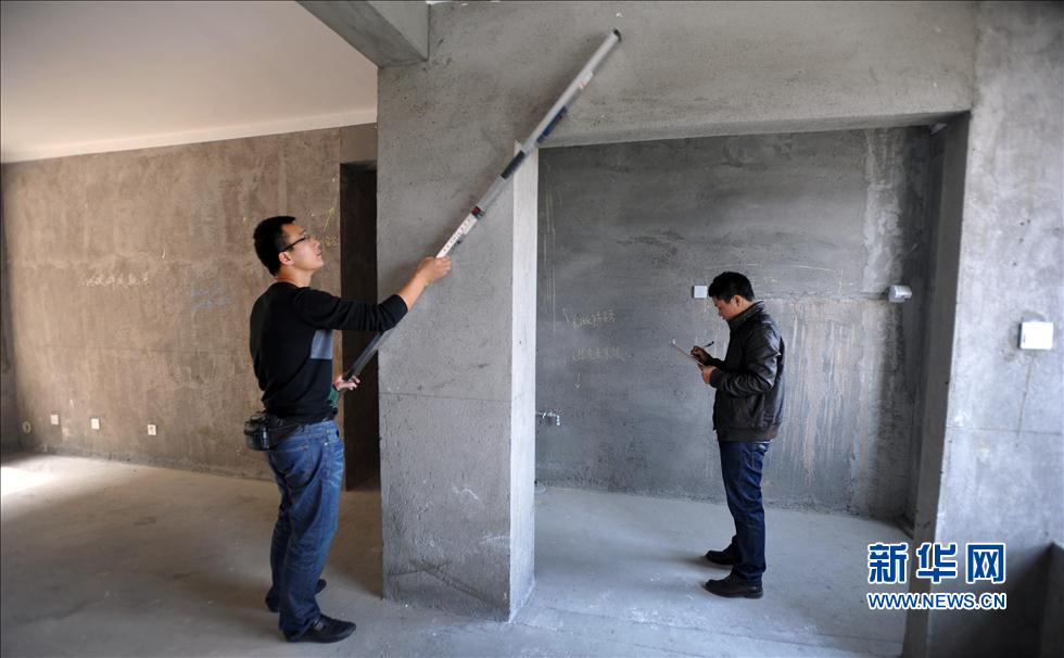 House inspector Shen Pu measures and examines a new house, and his colleague makes record. Photo taken on Oct. 26, 2012.   (Photo/Xinhua) 