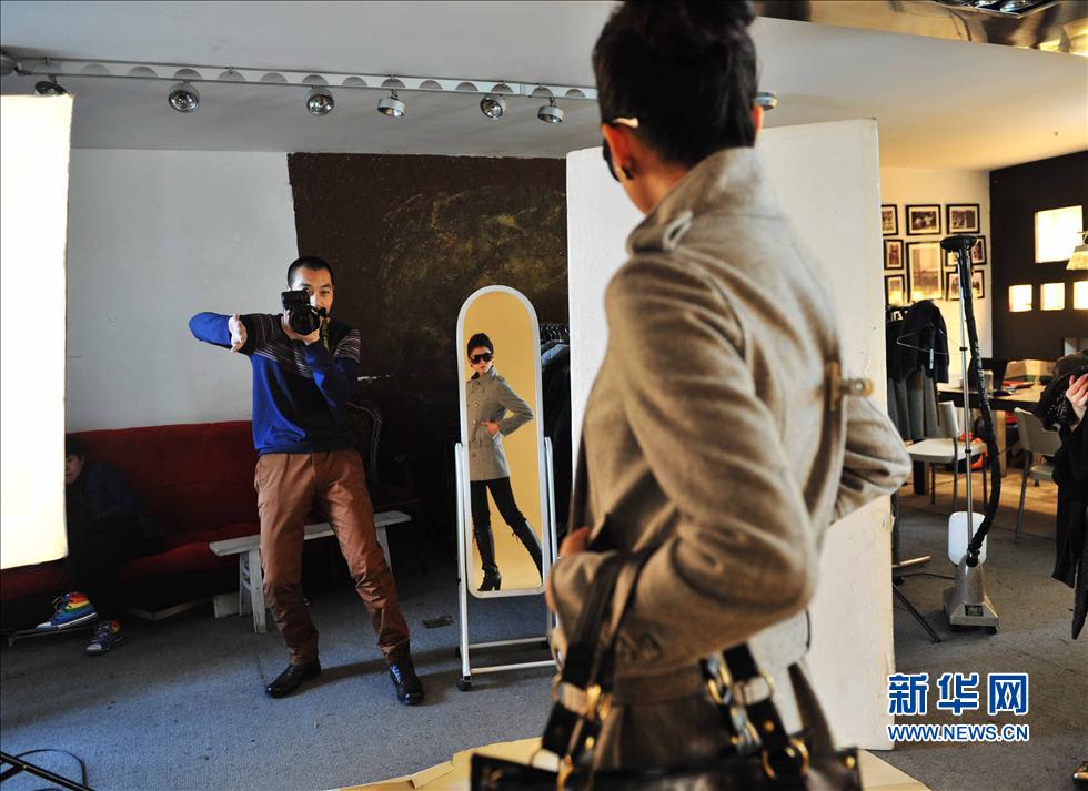 Zhang Kai takes promotional pictures for an online garment shop. With rapid growth in e-commerce, related services of e-business has been increased. More photographers seized this business opportunity to take pictures for online advertisement.  (Photo/Xinhua) 