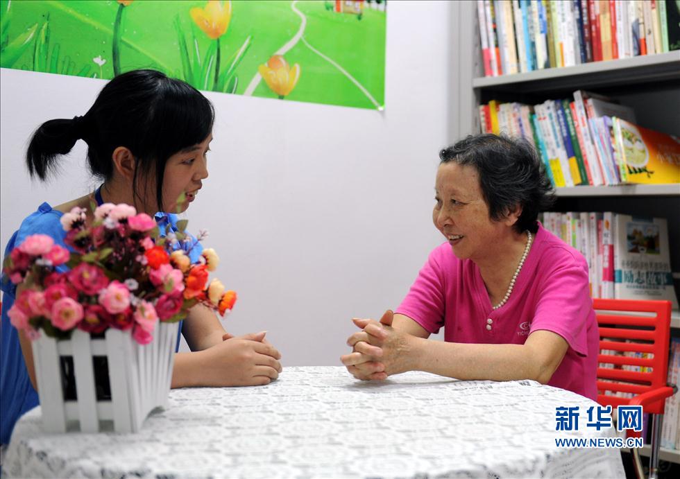 A caregiver talks with a senior person at a nursing house in Nanchang city. Photo taken on May 22, 2012. (Photo/Xinhua) 