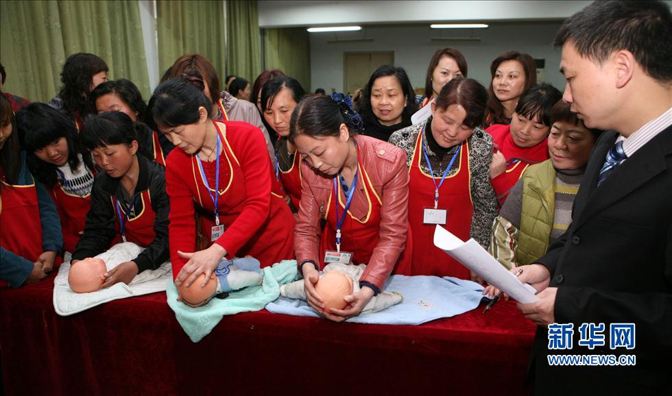 Confinement nannies and baby nurses receive working skill tests at a job fair organized by a local housekeeping company in Xiangyang city, Hunan province. Photo taken on April 12, 2012. (Photo/Xinhua)