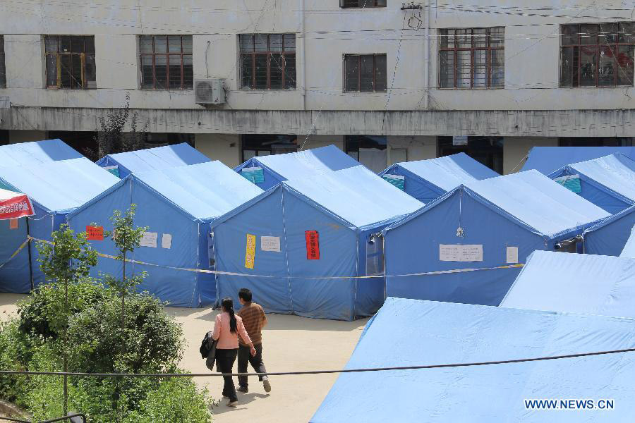Photo taken on July 31, 2013 shows the tents put up by the local government for people affected by the disasters in Niangniangba Town, Qinzhou District of Tianshui City, northwest China's Gansu Province. More than 20 people were dead or missing and about 1.22 million people were affected by the landslides and floods caused by strong rainfall in Tianshui in recent days. (Xinhua/Bai Liping)