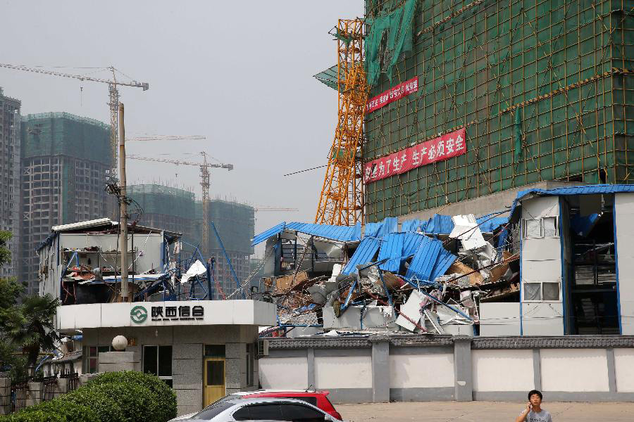 Photo taken on Aug. 1, 2013 shows the prefab houses damaged by the fallen tower crane at a construction site in Xi'an, capital of northwest China's Shaanxi Province. Due to sudden thundershower and strong wind, a tower crane at a construction site in Xi'an fell to the prefab houses where lived the construction workers, killing four people and hurting four others. (Xinhua/Hou Zhi) 