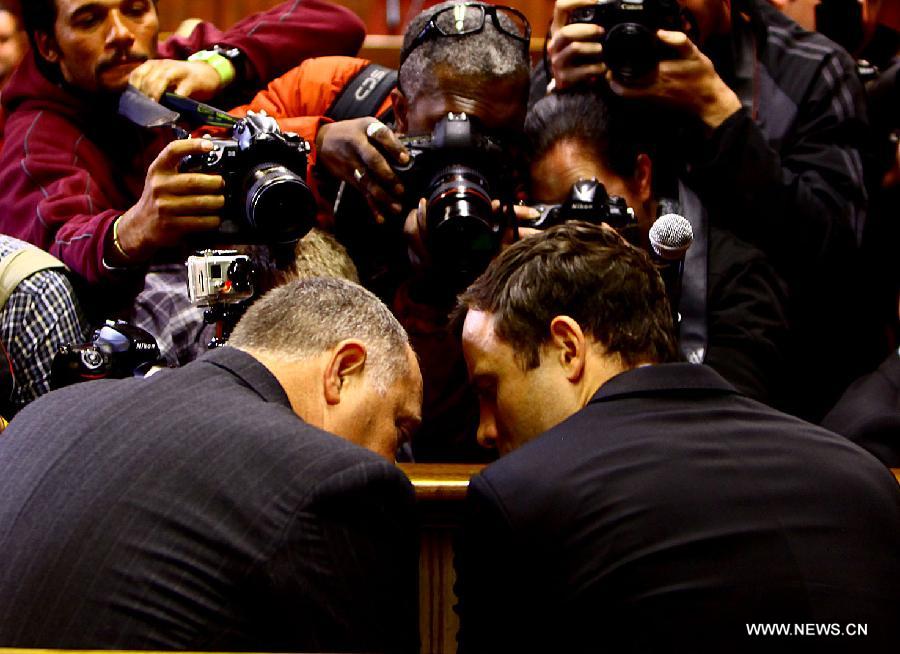 Paralympic running star Oscar Pistorius (R) reacts inside the magistrates court in Pretoria, South Africa, on Aug.19, 2013. Pistorius was back in court Monday morning to hear murder charges against him. The trial date of murder-accused paralympian Oscar Pistorius has been set for March 3, 2014, Prosecutor Gerrie Nel announced here on Monday. (Xinhua/Lali Sadger)