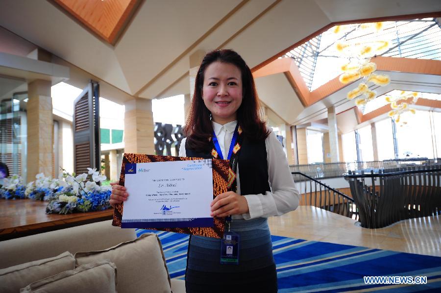 Chinese delegate Lu Aihui holds certificate of appreciation for the rigorous support as young woman innovator in economic development during the 3rd Women and the Economy Forum in Bali, Indonesia, Sept. 6. 2013. The event will be held from Sept. 6 to 8. (Xinhua/Zulkarnain) 