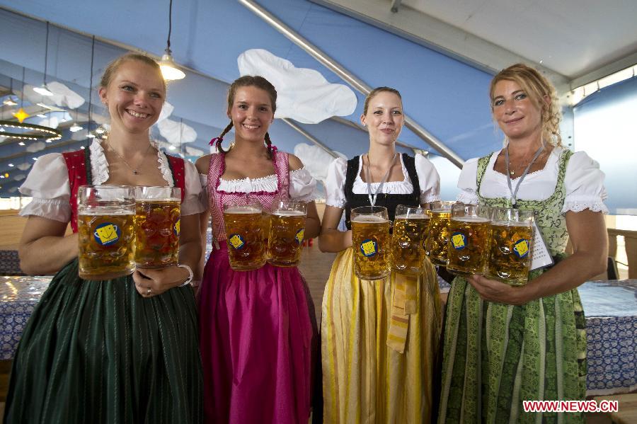 Waitresses from Munich of Germany pose for photos at an Oktoberfest beer festival affiliated to the original version of the German event at the Olympic Park in Beijing, capital of China, Sept. 6, 2013. German beer, Bavarian food, and bands from Munich would serve the public throughout the two-week festival. This was the first time for the Munich Oktoberfest, the world's biggest beer festival, to be staged in Beijing. (Xinhua/Zhao Bing) 