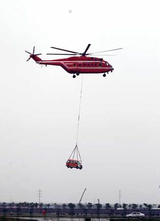 An AC 313 helicopter lifts a vehicle from the scene of a simulated traffic accident during the opening ceremony of the Second China Helicopter Expo in Tianjin on Thursday.Photos by Jia Lei / for China Daily 