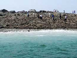 Pakistanis walk on newly-emerged island after quake