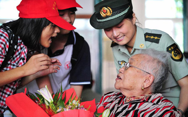 Youth volunteers and a policewoman chat with Su Mianmian, 90-year-old elder living in the welfare house, in Quanzhou, southeast China's Fujian Province, Oct. 13, 2013. People from all walks of life celebrated the Seniors' Day on Sunday, also the traditional Double Ninth Festival. It was the first time the holiday was observed since it was written into the newly-revised law on the protection of the rights and interests of the elders. (Xinhua/Wei Peiquan)