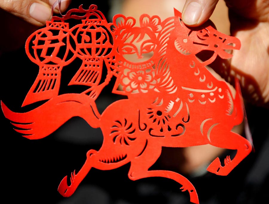 Chen Longyong shows his paper cutting work on December 29, 2013. Chen, who is in his 70's and is from Yancheng, Jiangsu province, has been making paper cuts for over 40 years. He recently created several horse-themed works to welcome the New Year, which is the Year of the Horse according to the Chinese zodiac calendar. (Photo/Xinhua)