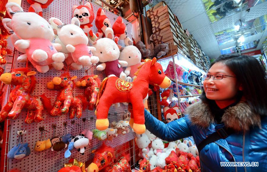A consumer selects New Year decorations at a shopping mall in Nanchang, capital of east China's Jiangxi Province, Jan. 9, 2014. (Xinhua/Zhou Ke)