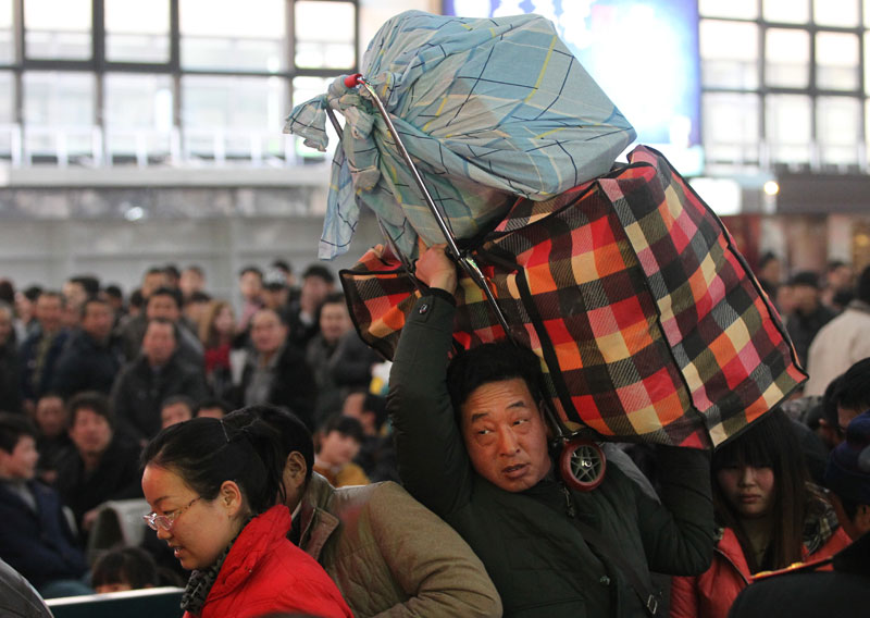 Passengers wait to board a train at Beijing West Railway Station on Tuesday ahead of the 40-day Spring Festival travel rush, which starts on Thursday. This year’s annual travel rush is expected to witness 3.62 billion trips, an increase of 200 million more than last year. [Photo by Zou Hong/China Daily]