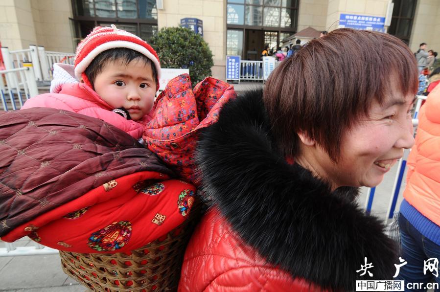A little "migratory bird" goes back home on her mother's back. (cnr.cn/Wang Haibin)