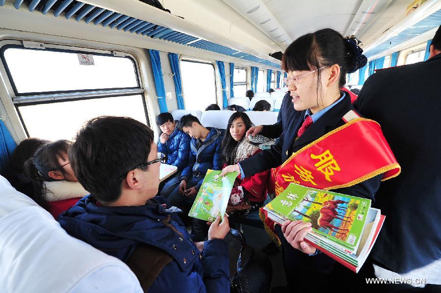 A steward distributes free books and magazines to passengers on the train from Yinchuan to Guangzhou on Jan. 21, 2014. Many special services were provided on the trains from Yinchuan to Guangzhou during the Spring Festival travel rush. (Xinhua/Peng Zhaozhi)