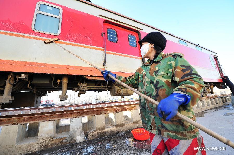 A worker cleans the exterior of a passenger car at Yinchuan Railway Station in Yinchuan, capital of northwest China's Ningxia Hui Autonomous Region, Jan. 20, 2014. It is estimated that over a million passengers will travel by trains operated by the Yinchuan passenger section of the Lanzhou Railway Bureau, which is in charge of railway transport in Ningxia and Gansu, during the 2014 "Chunyun", a 40-day Spring Festival travel rush period starting from Jan. 16. About 1,800 support crew members from the Lanzhou Railway Bureau's Yinchuan passenger section will be dedicated to services during the "Chunyun". (Xinhua/Peng Zhaozhi) 