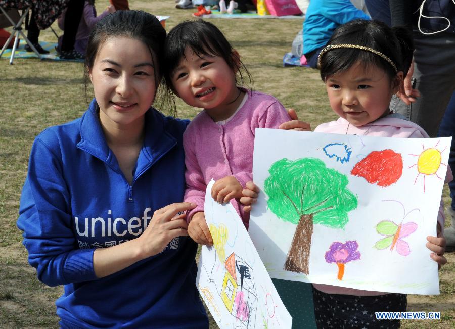 Retired four-time Olympic diving champion Guo Jingjing (L) poses for photos with children in Hong Kong, south China, Jan. 25, 2014. Guo was appointed as UNICEF HK Ambassador on Saturday. (Xinhua/Lo Ping Fai)