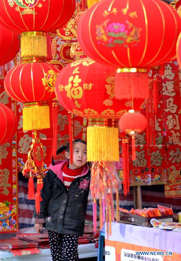 A girl watches spring festival scrolls in a trading center in Wan'an County, east China's Jiangxi Province, Jan. 25, 2014. With the Spring Festival approaching, special purchases for the lunar new year with a fair price attracted the Chinese people. (Xinhua/Zhou Ke)