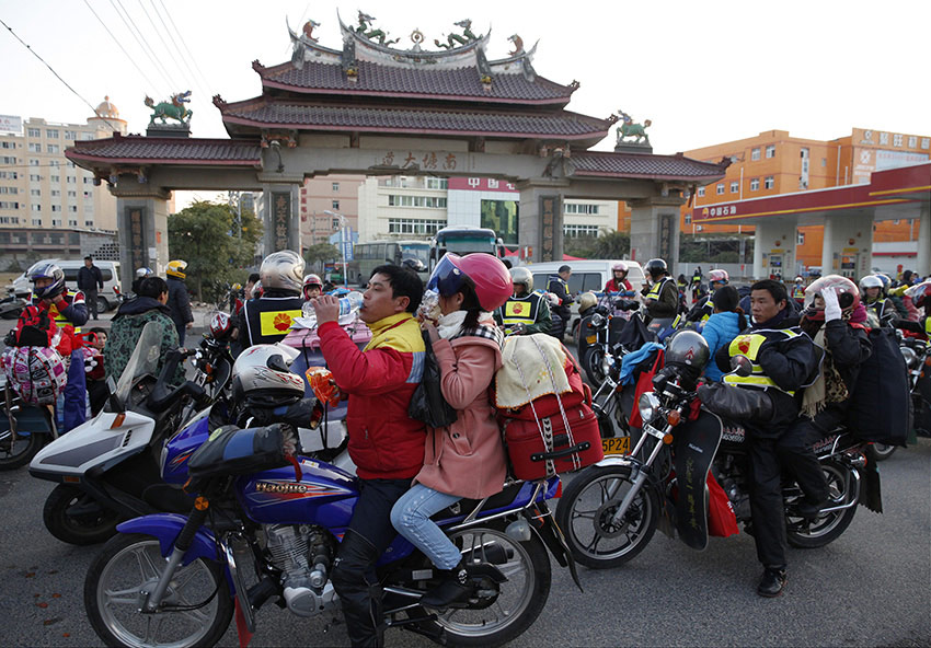A group of migrant workers depart from Nantang Avenue in Jinjiang City, southeastern China's Fujian Province, to embark on their 500-kilometer-long journey home by motorcycle, 7:08 a.m., Jan. 23, 2014. (Xinhua/Wang Shen)