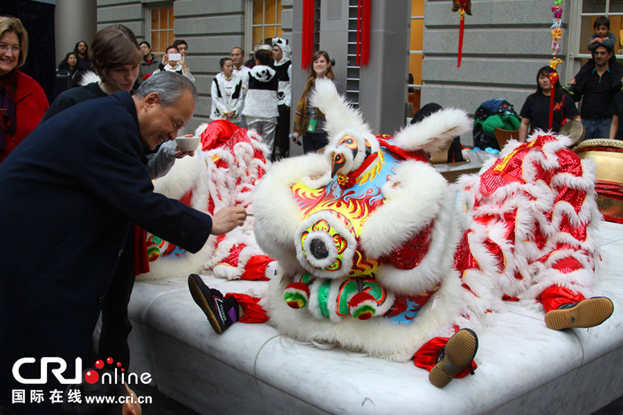 Ambassador Cui Tiankai kicks off the Chinese New Year Family Day by giving the  finishing touch to a lion costume in Washington D.C. Jan. 25, 2014. (Photo/CRI Online)