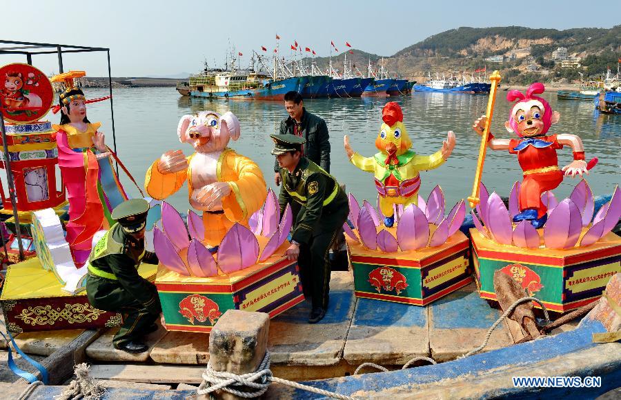 Border police load lanterns in Lianjiang, southeast China's Fujian province, Jan. 28, 2014. A total of 1029 lanterns were shipped Tuesday from Chinese mainland to Matsu in Taiwan for the Lantern Festival there. (Xinhua/Zhang Guojun)