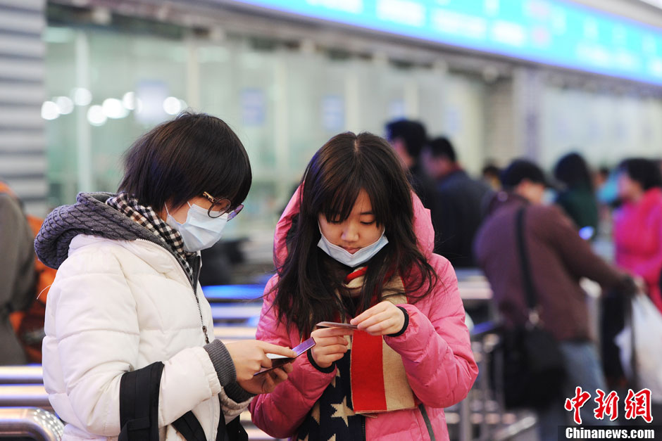 Two college students Zhou (left) and Xu (right) waiting to buy tickets at Beijing West Railway Station in Beijing, Jan. 21, 2014. Only Zhou has successfully got a ticket. (Xinhua/Zhang Longyun)